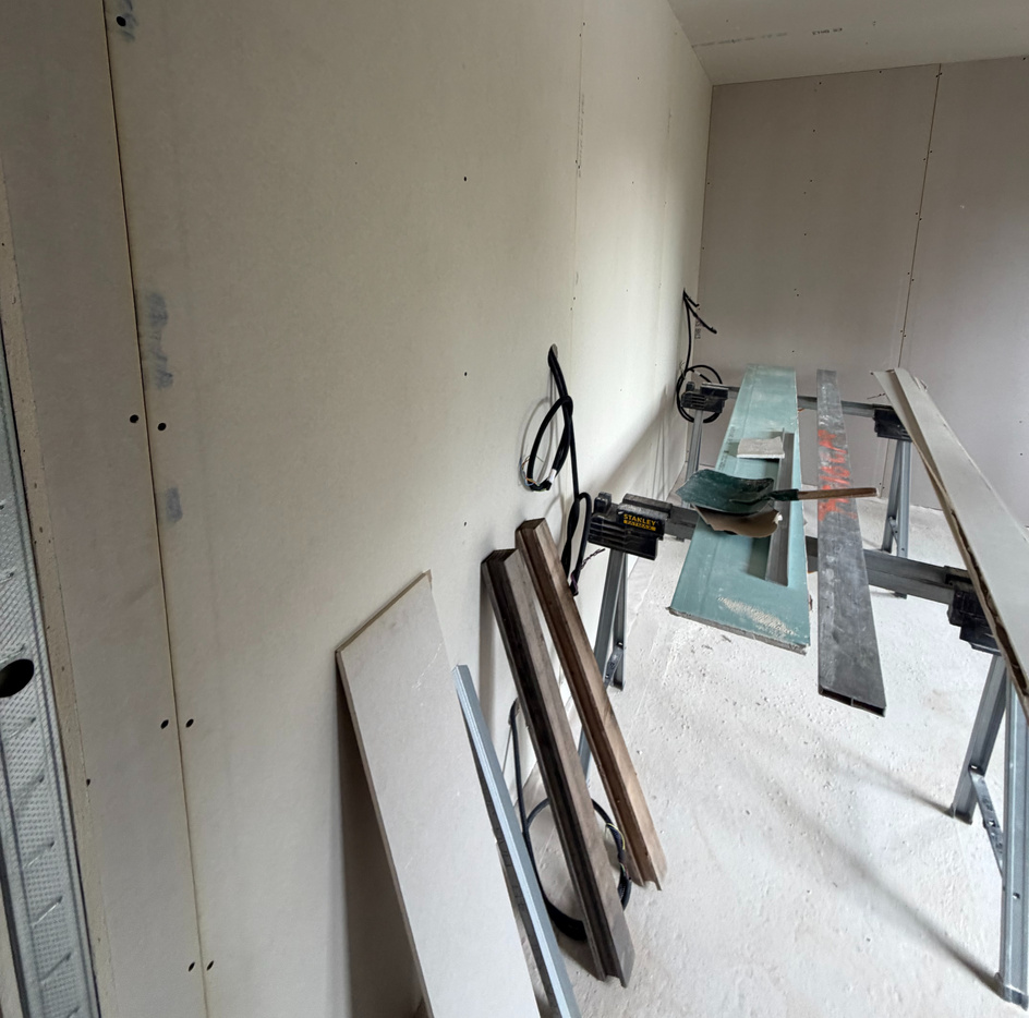 Pièce en rénovation avec cloisons placo et menuiseries entreposées, suivi de chantier Atelier Luzons